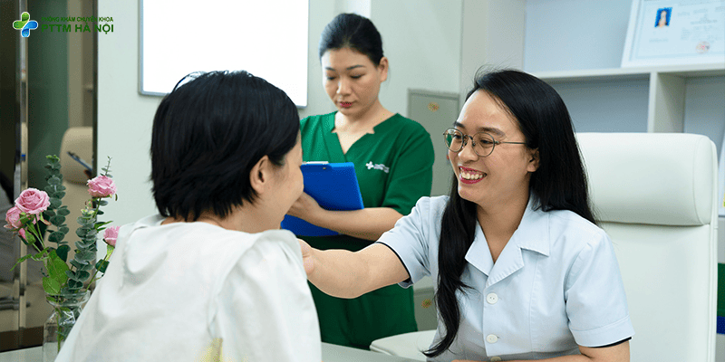 Bác sĩ thẩm mỹ đang tươi cười thăm khám trực tiếp cho khách hàng tại phòng khám